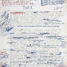 An editor reviewing and trimming pages of a manuscript