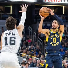 A basketball player attempting a shot at the basket.