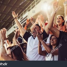 A large crowd cheering loudly at a sporting event