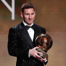 Lionel Messi holding a Ballon d’Or trophy