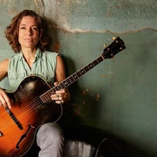 Ani DiFranco performing with a guitar
