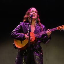 A singer performing a wordless vocal refrain onstage.