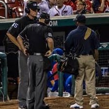 A baseball umpire watching a play on the field