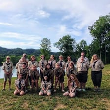 A group of scouts gathered outdoors in uniform.