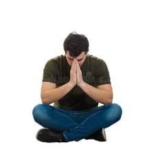 A person sitting with a discouraged, hopeless posture.