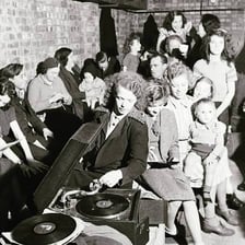 A DJ performing behind a console in a dance club