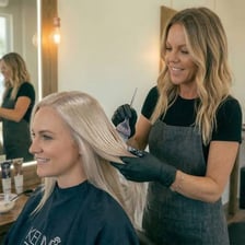 A stylist applying hair color in a salon