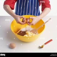 A person adding an ingredient to a bowl