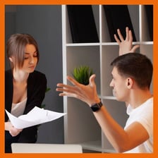 Two people talking while one points out a small flaw.