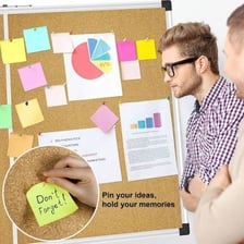 A thumbtack securing a paper notice to a bulletin board.