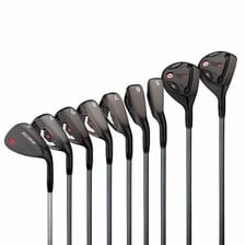 A set of golf iron clubs resting near a golf course.