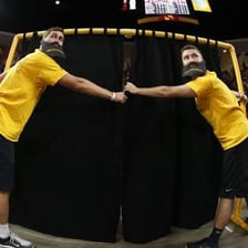 Fans gesturing and shouting taunts toward an opposing team.