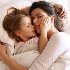 A mother cuddling a toddler