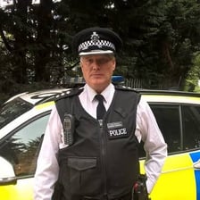 A British police detective chief inspector wears a formal police uniform.
