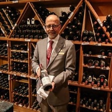 A sommelier tasting wine in a wine cellar.