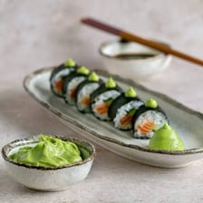 A mound of green wasabi paste served beside sushi.