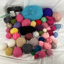 Colorful balls of yarn beside knitting needles.