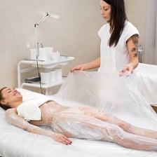 A spa treatment scene showing a person receiving a body wrap.
