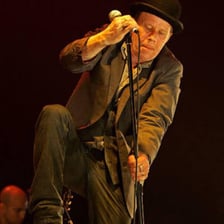 Tom Waits performing live on a concert stage
