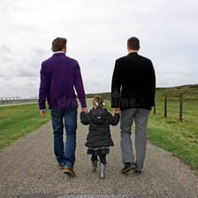 An adult walking while a child follows behind