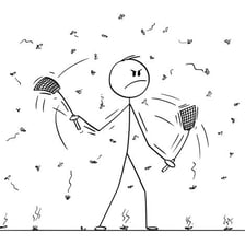 A person appearing annoyed while swatting at an insect.