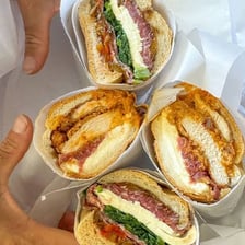 A deli counter displaying prepared foods and sandwiches.