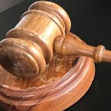 A gavel beside papers from a formal meeting