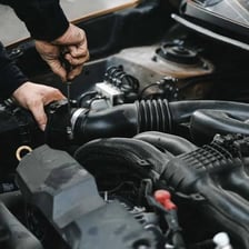 A mechanic servicing a car during a tune-up.