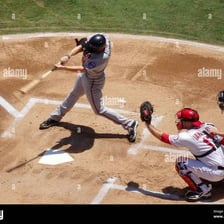 A baseball batter swinging and missing a pitch