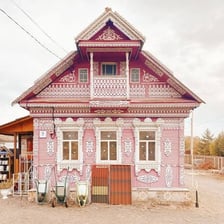 A traditional Russian dacha surrounded by greenery.