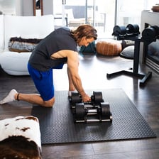 Several padded exercise mats lie on a gym floor.