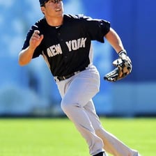 A baseball fielder reaching up to catch a fly ball