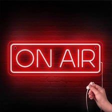 A glowing red studio sign reading “ON AIR.”