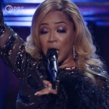 Erica Campbell performing on stage