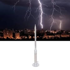 A lightning rod mounted on a rooftop beneath storm clouds