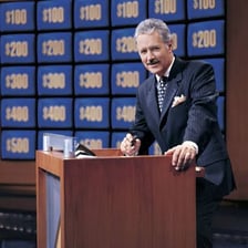 A quiz-show host standing at a podium