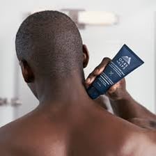 An athlete applying cream to a sore muscle