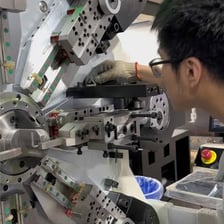 An engineer making a careful adjustment to a machine.