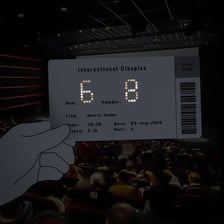 A theater ticket displaying a row and seat assignment.