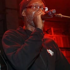 A hip-hop performer holding a microphone on stage