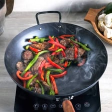 Several round-bottomed woks used for stir-frying.