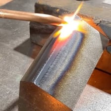 A welder joining two pieces of metal.