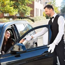 A parking valet handing a car back to a customer