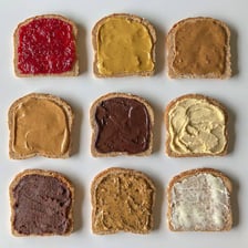 A dish of margarine being spread on bread