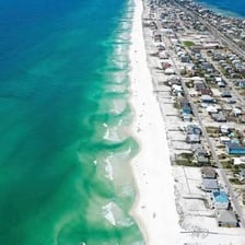 A beach with visible rip-current conditions near the shoreline.