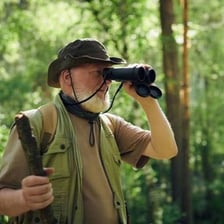 A person noticing a distant object through binoculars