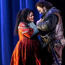 A female opera singer performing on a stage.