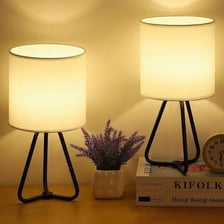 A table lamp sitting on a bedside table.
