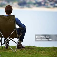 A person leaning back comfortably in a chair.