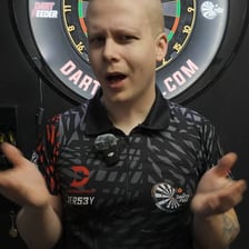 A darts player concentrating while aiming at a dartboard